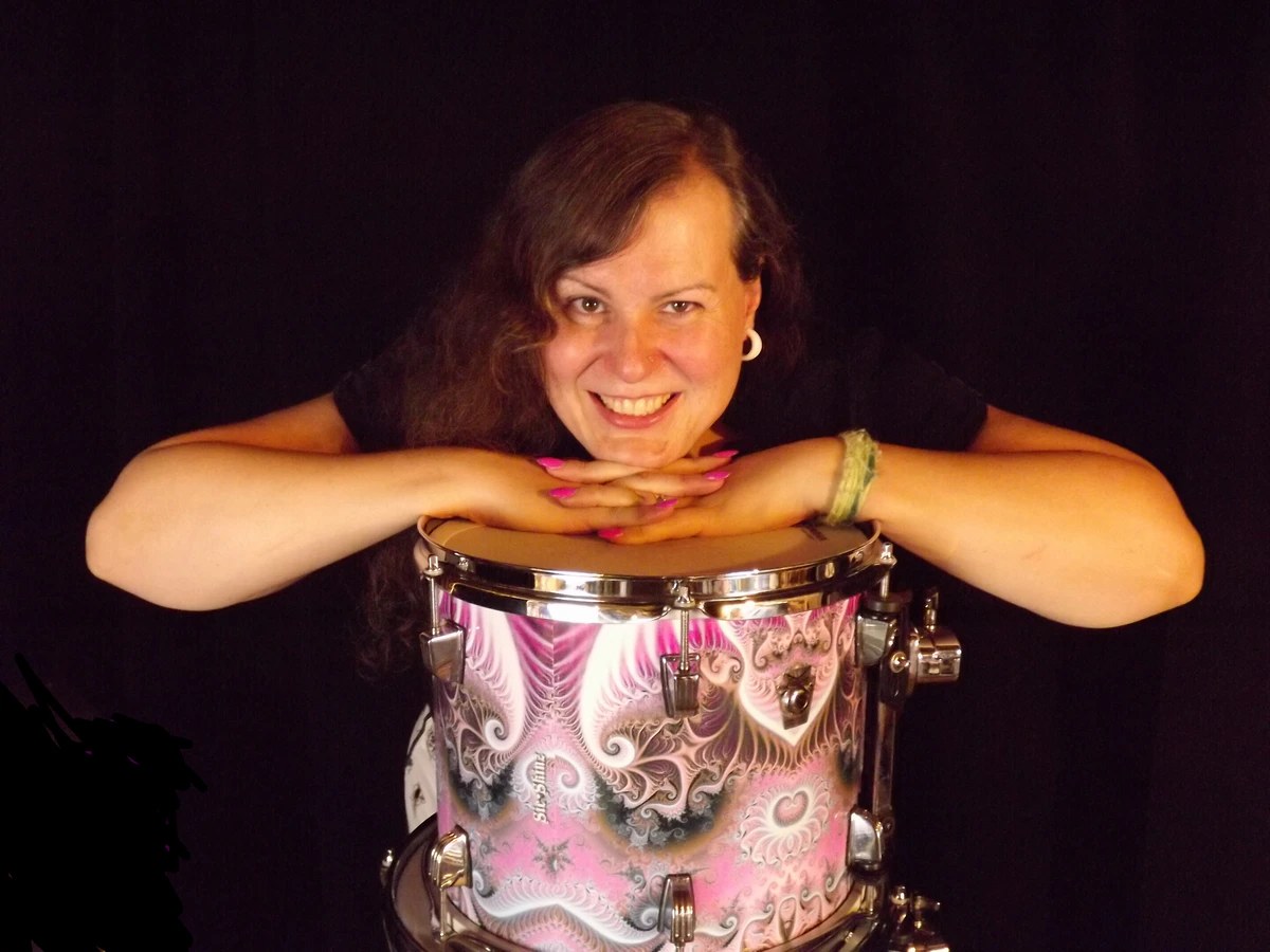 Penny Larson resting on her custom pink Sic Shrine drum kit