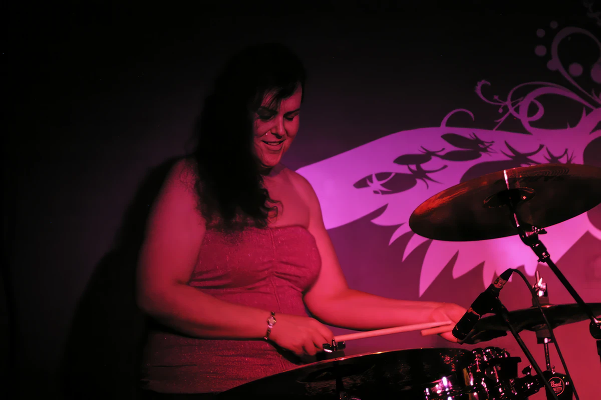 Penny Larson playing drums at a Boston club