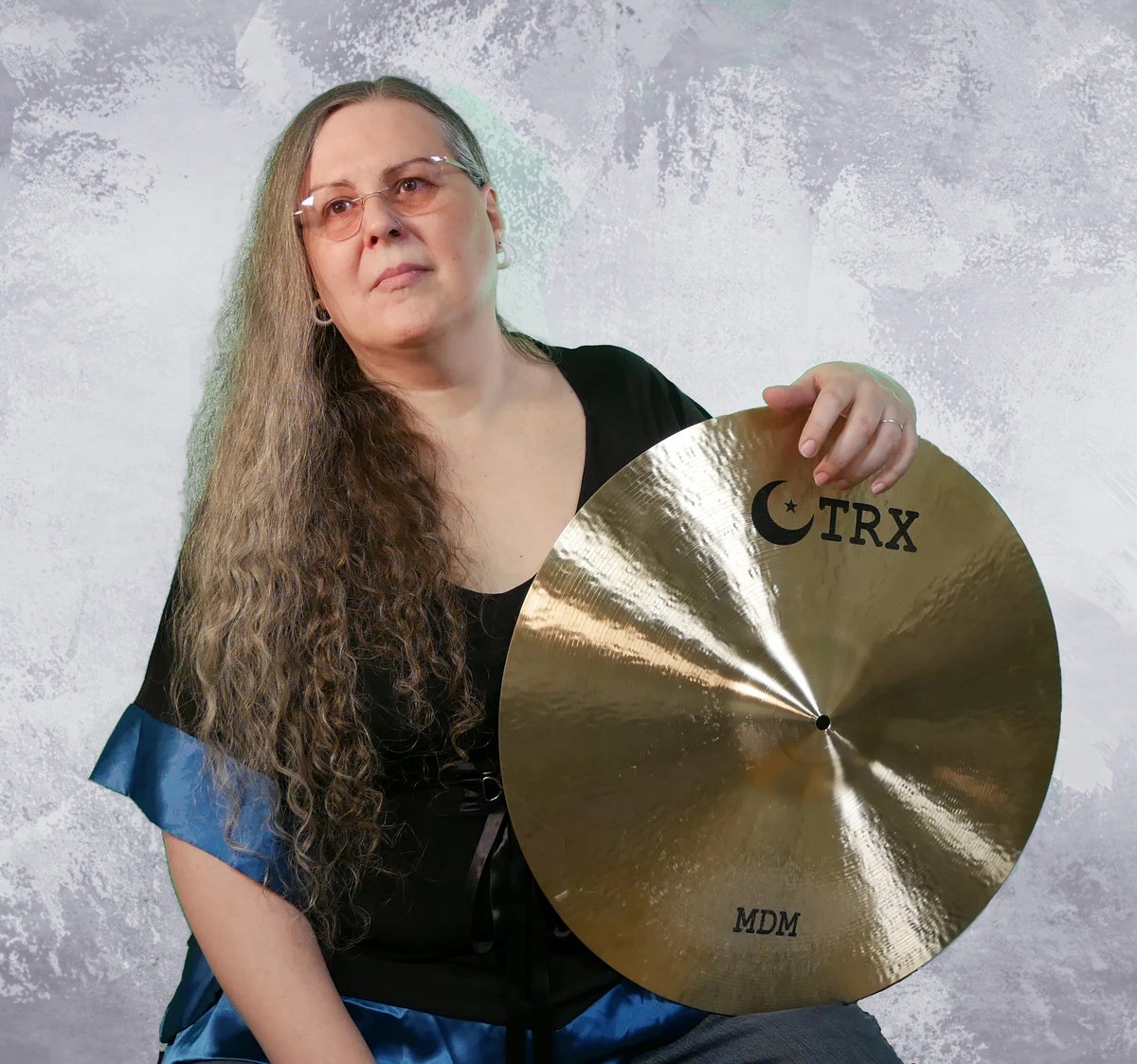 Penny Larson holding a TRX cymbal — endorser portrait