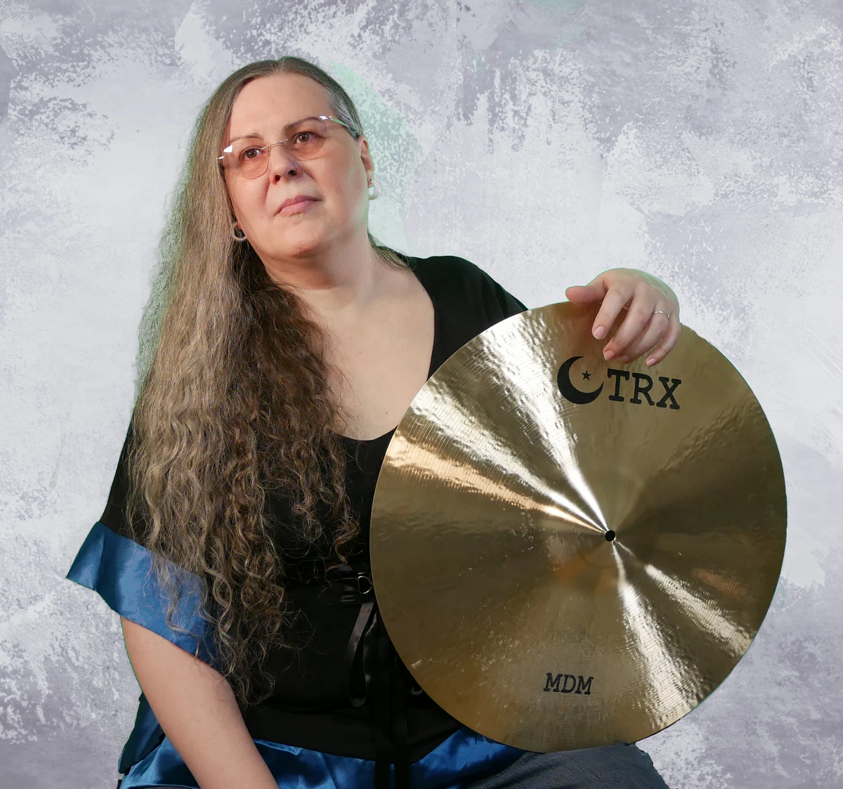 Penny Larson holding TRX Cymbals as a professional endorser